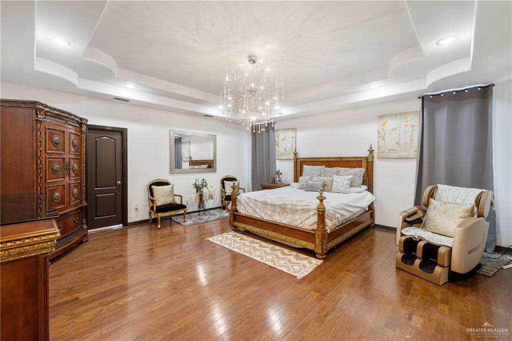 8413 North Main Street McAllen, TX 78504 - Photo 12 of 37 a bedroom with a bed and a chandelier