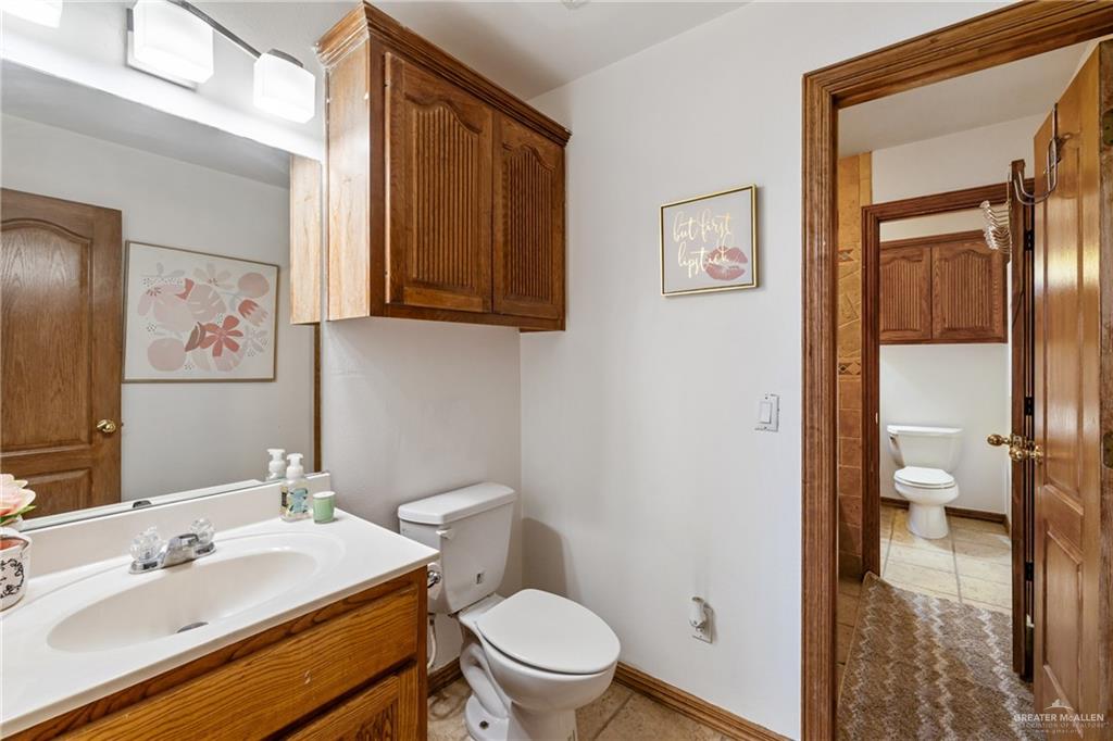 8413 North Main Street McAllen, TX 78504 - Photo 18 of 37 a bathroom with a sink a toilet and shower curtain