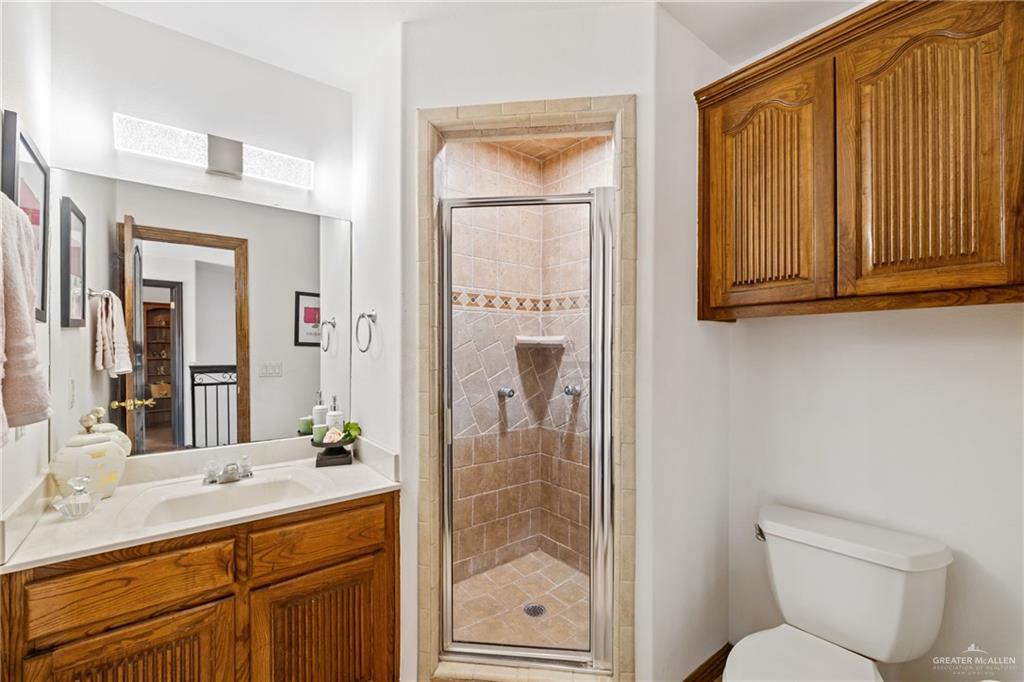 8413 North Main Street McAllen, TX 78504 - Photo 20 of 37 a bathroom with a toilet a sink and glass door