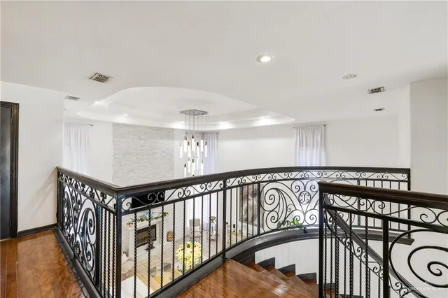 a view of a hallway with wooden floor and stairs