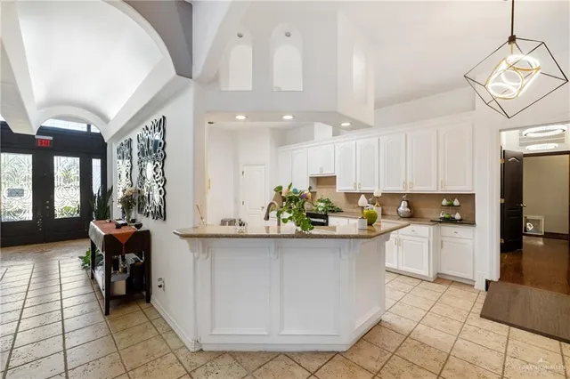a kitchen with a white cabinets and chairs