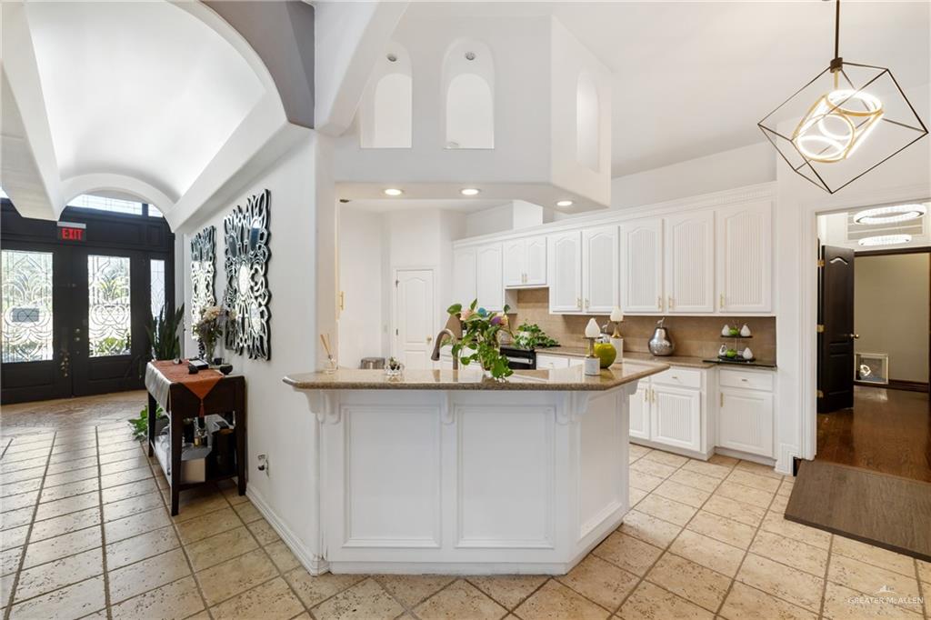 8413 North Main Street McAllen, TX 78504 - Photo 10 of 37 a kitchen with a white cabinets and chairs