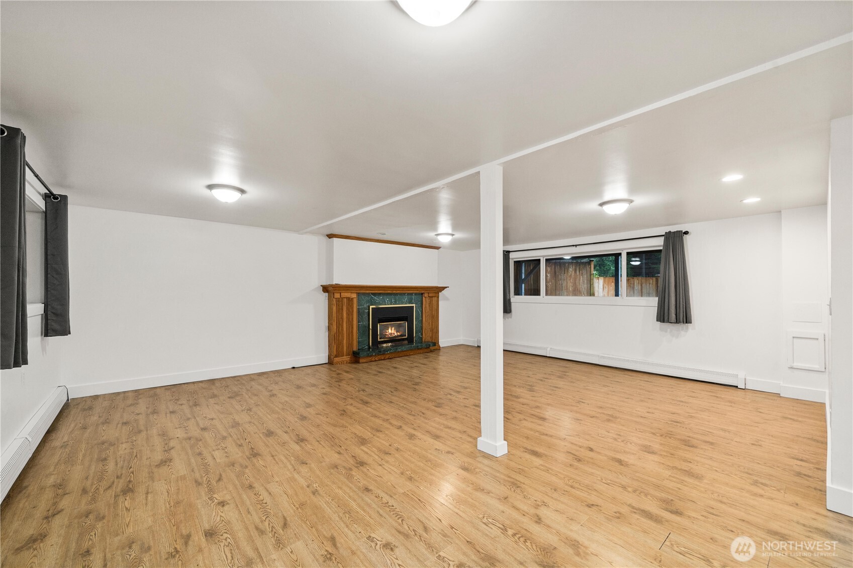 114 Southwest 313th Street Federal Way, WA 98023 - Photo 24 of 40 a view of an empty room with wooden floor and a kitchen