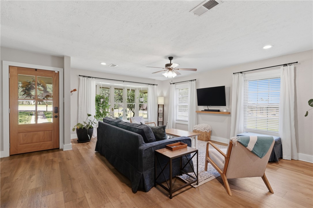 515 Crescent Drive Bryan, TX 77801 - Photo 6 of 43 Inviting living space featuring wood-finish flooring, a full-lite entry door, a bay window, recessed lighting, and a ceiling fan