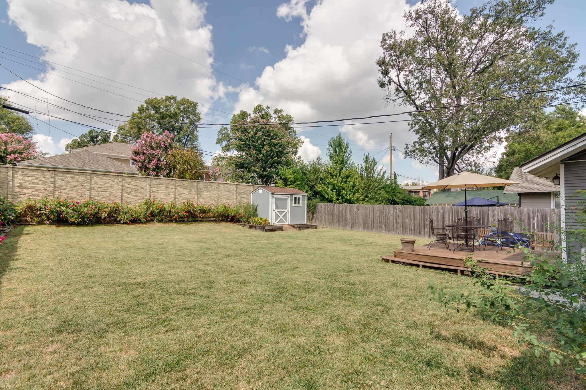 279 Angelus Street Memphis, TN 38112 - Photo 30 of 34 a view of a backyard with table and chairs under an umbrella