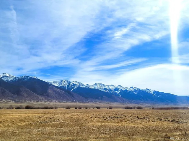 a view of a large mountain with sunset in the background