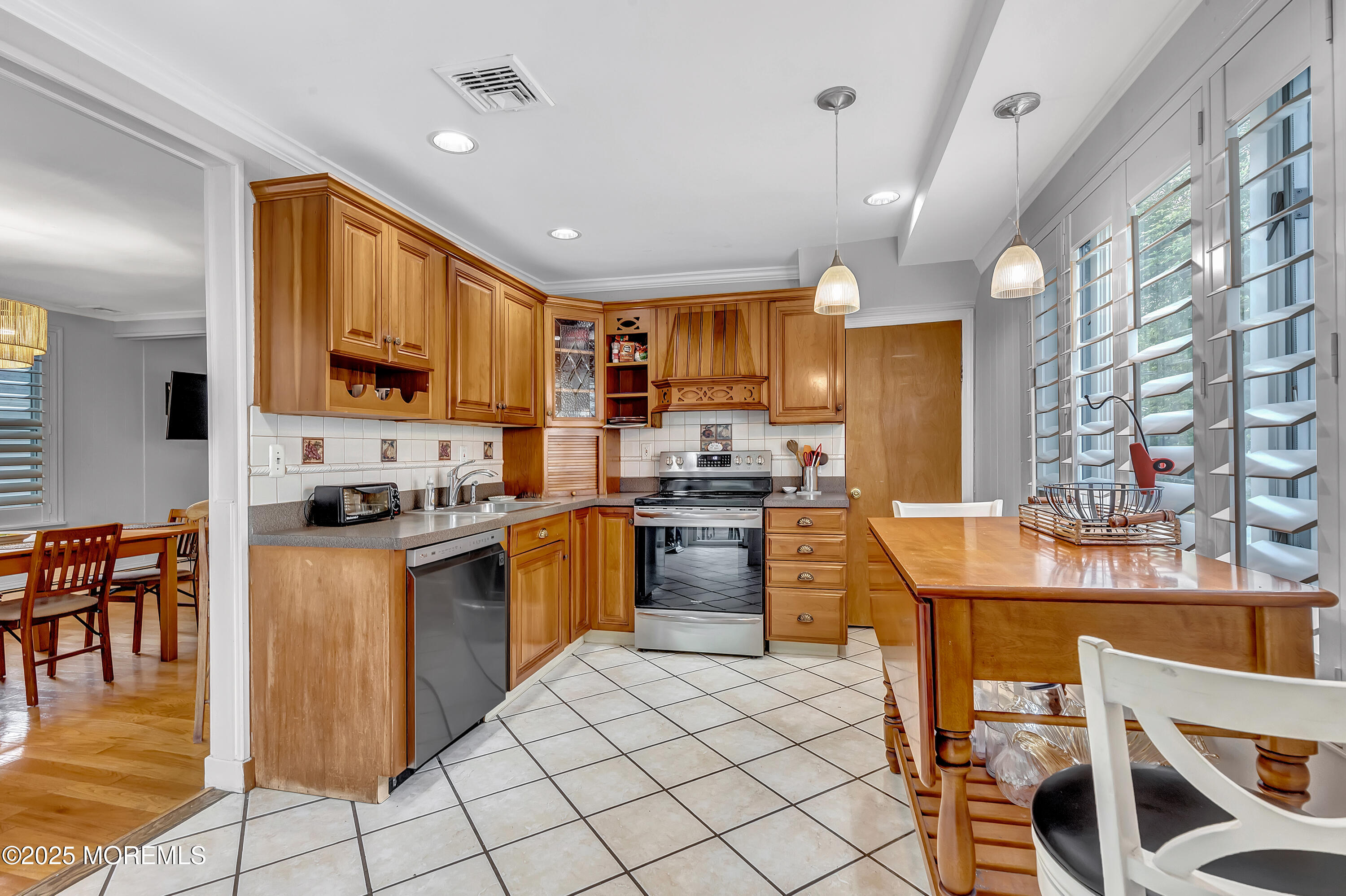 370 East Main Street Manasquan, NJ 08736 - Photo 12 of 34 a kitchen with stainless steel appliances granite countertop a stove top oven a sink dishwasher a dining table and chairs with wooden floor