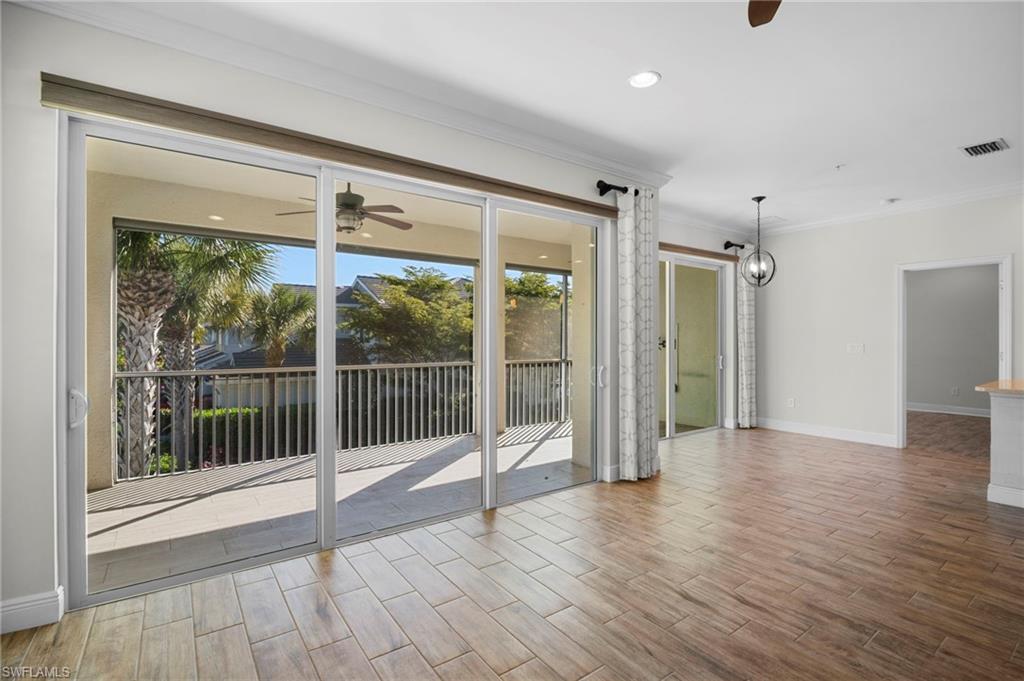 6934 Avalon Circle, Unit 405 Naples, FL 34112 - Photo 8 of 16 Spare room featuring a ceiling fan, wood finish floors, crown molding, recessed lighting, and a chandelier