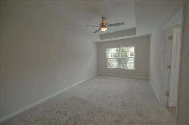 an empty room with a ceiling fan and a window