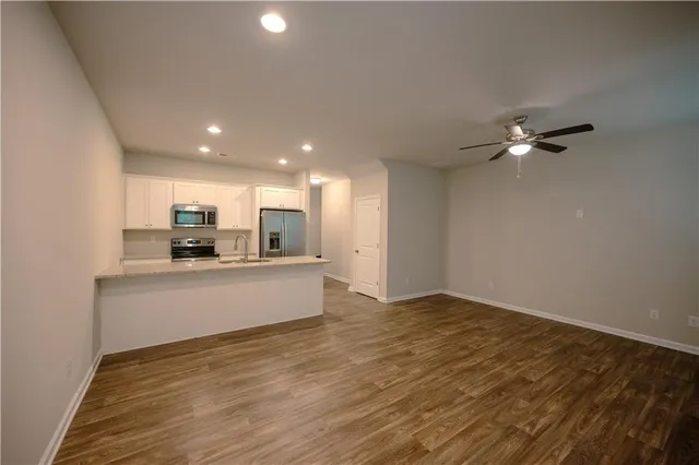 a view of kitchen with sink wooden floor and window