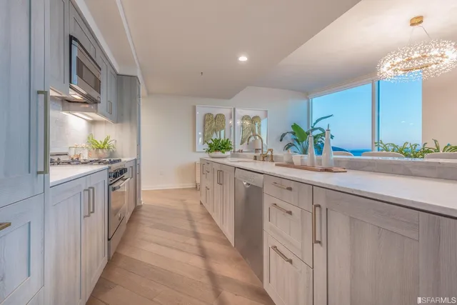 a view of a dining room with furniture a potted plant and wooden floor