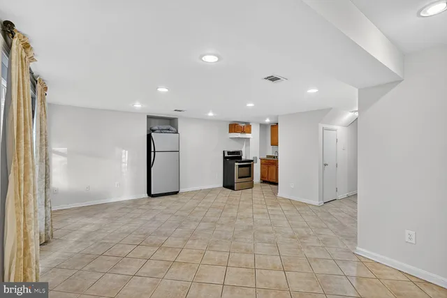 a view of empty room with kitchen
