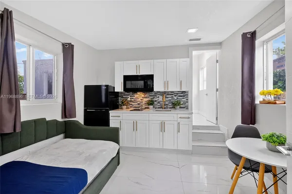 a kitchen with stainless steel appliances a sink a refrigerator a counter space and cabinets