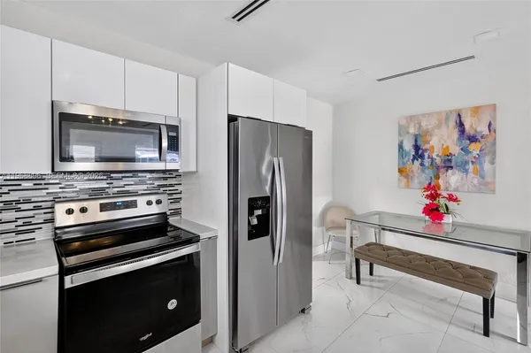 a kitchen with stainless steel appliances a refrigerator sink and microwave