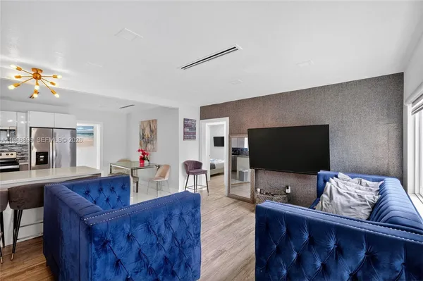 a living room with furniture and a refrigerator