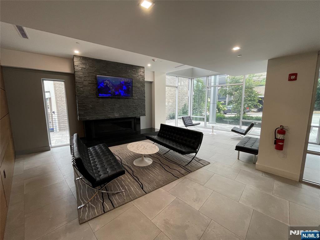 2150 North Central Road, Unit 410 Fort Lee, NJ 07024 - Photo 12 of 15 a living room with furniture and a flat screen tv