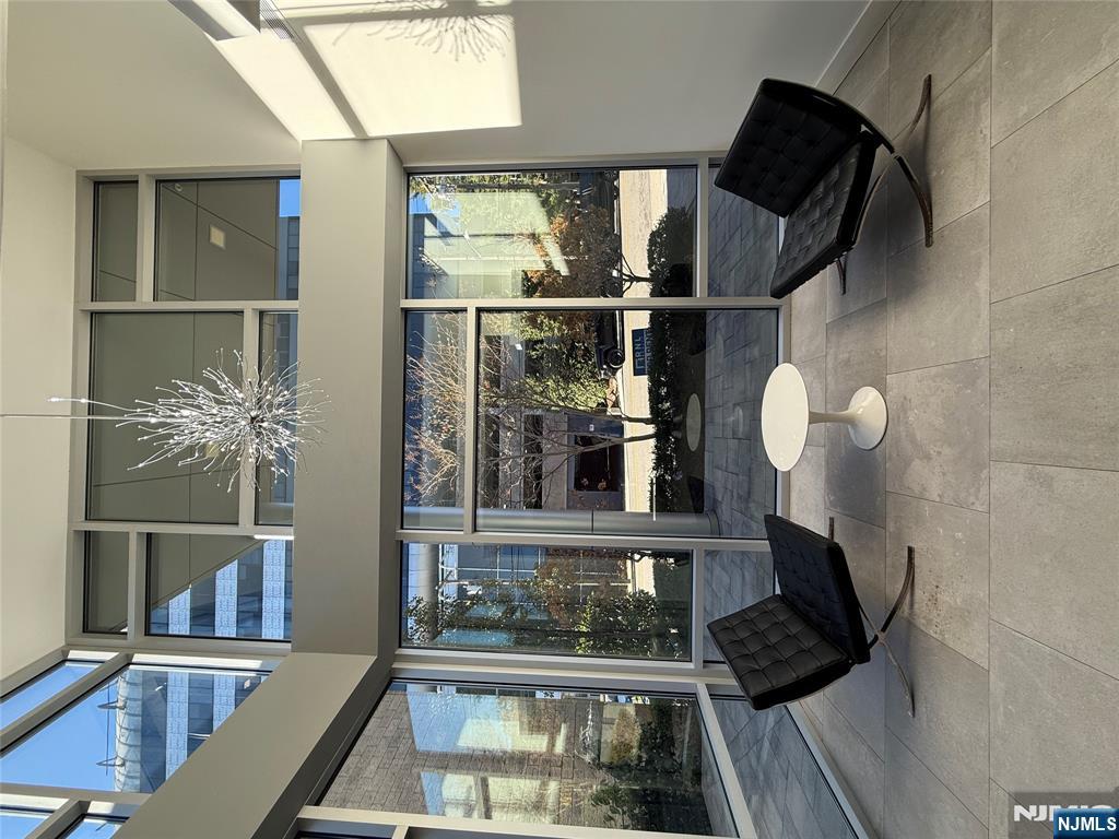 2150 North Central Road, Unit 410 Fort Lee, NJ 07024 - Photo 13 of 15 a living room with furniture and a floor to ceiling window
