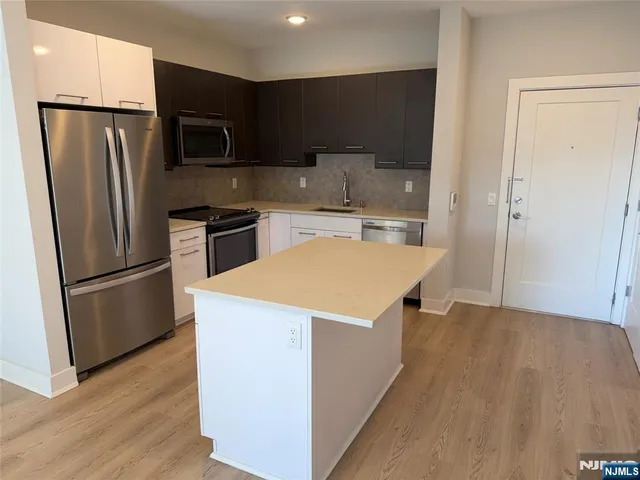 a kitchen with stainless steel appliances a refrigerator a stove a sink and a center island