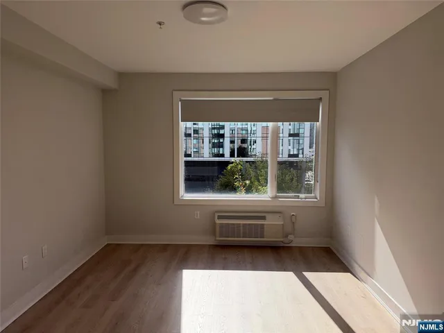 an empty room with wooden floor and a window