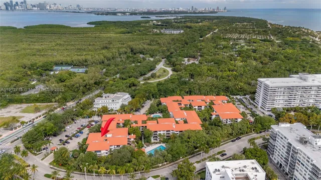 an aerial view of residential houses with outdoor space and trees