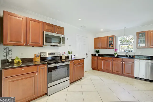 a kitchen with stainless steel appliances granite countertop a stove a sink and a microwave