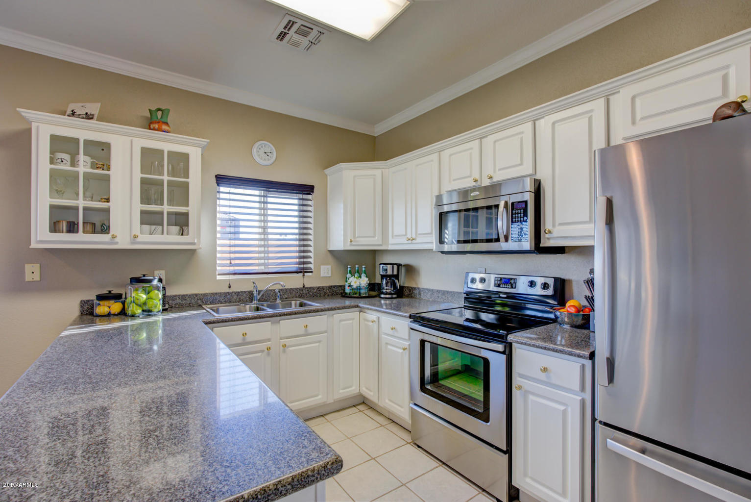 8940 West Olive Avenue, Unit 15 Peoria, AZ 85345 - Photo 1 of 9 a kitchen with stainless steel appliances granite countertop a stove a sink dishwasher a refrigerator and a microwave
