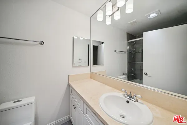 a bathroom with a sink a toilet and a mirror