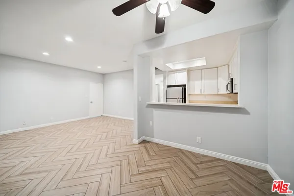 a view of empty room with wooden floor and window