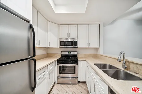 a kitchen with white cabinets and white appliances