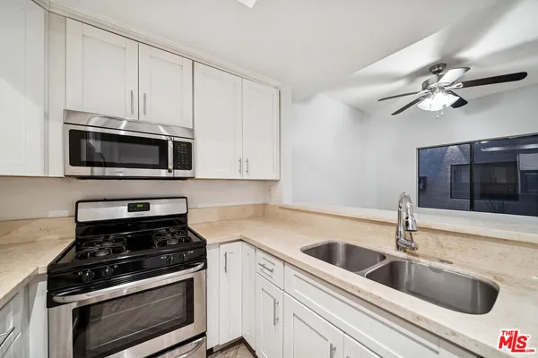 a kitchen with stainless steel appliances a stove a sink and a microwave