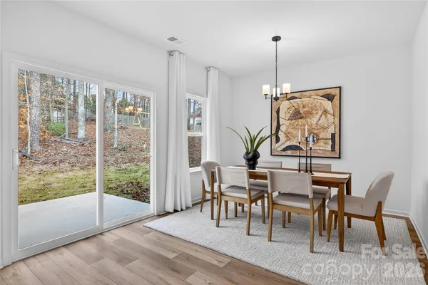 a dining room with furniture a chandelier and wooden floor