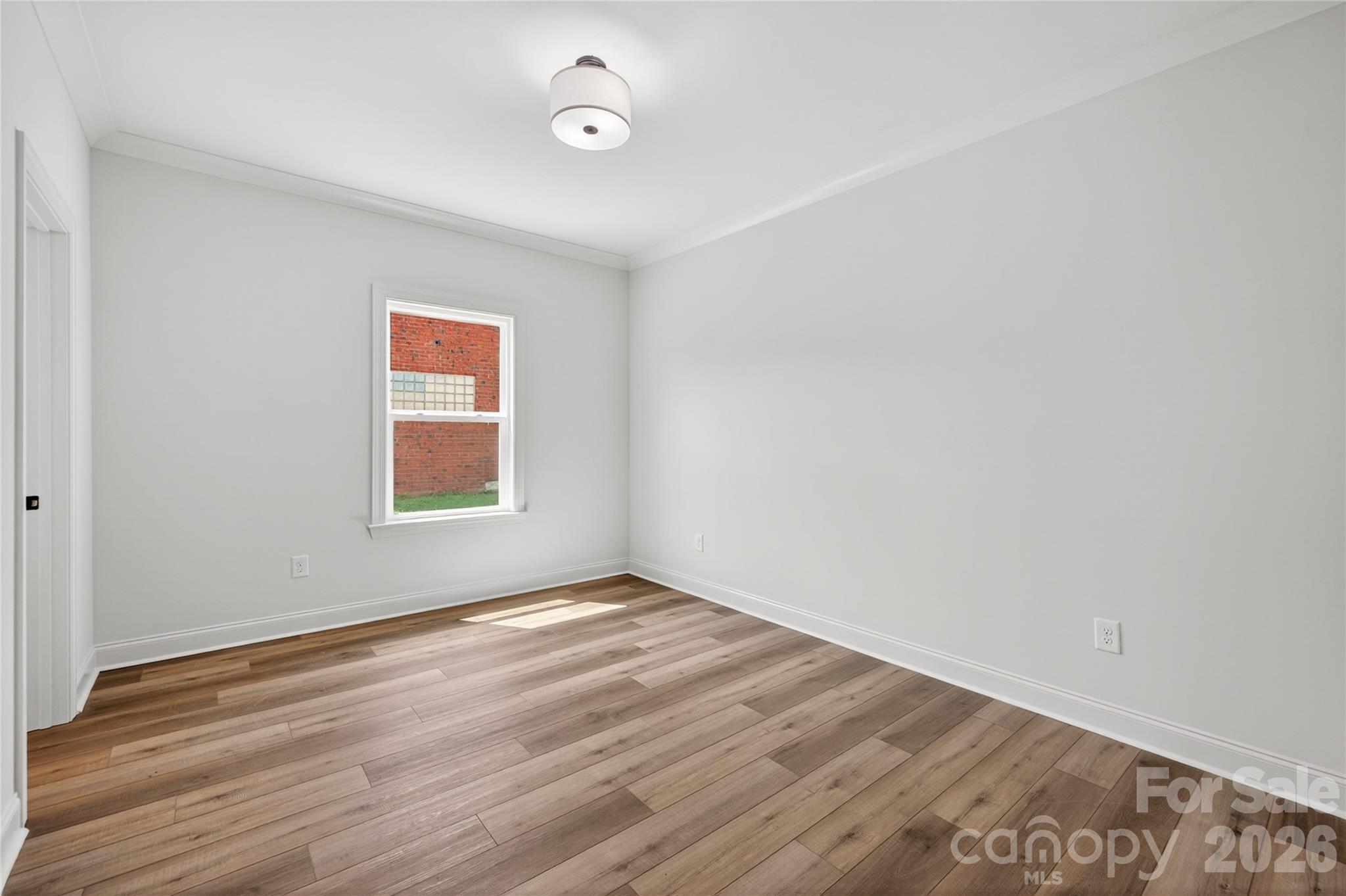 2965 Polk And White Road Charlotte, NC 28269 - Photo 23 of 38 an empty room with wooden floor and windows