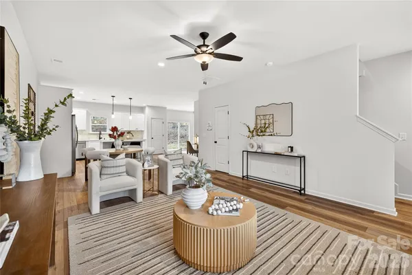 a living room with furniture kitchen view and a potted plant