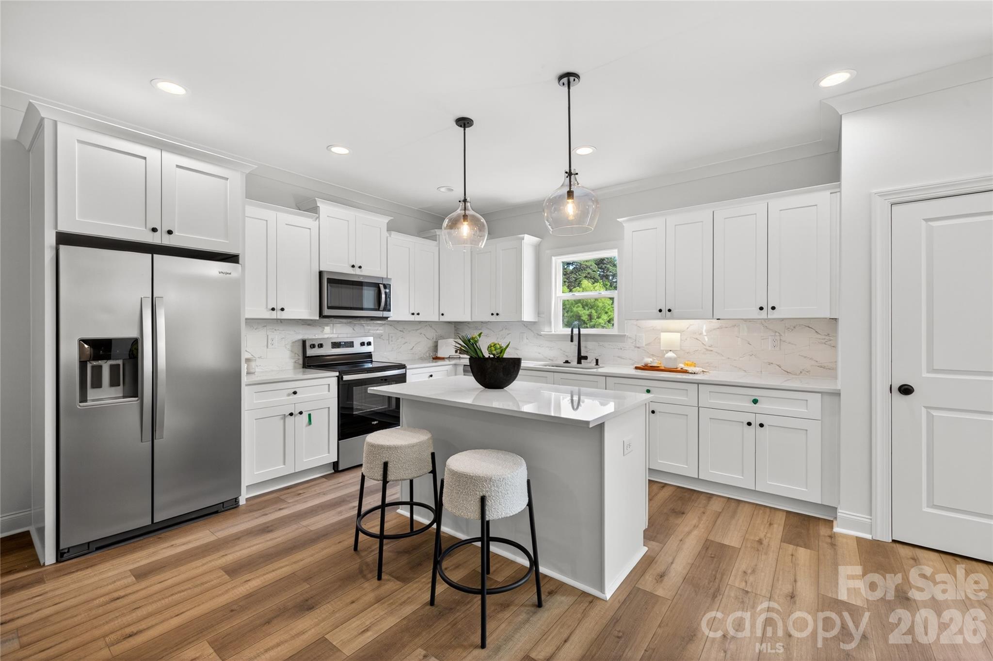 2965 Polk And White Road Charlotte, NC 28269 - Photo 7 of 38 a kitchen with white cabinets stainless steel appliances and wooden floor