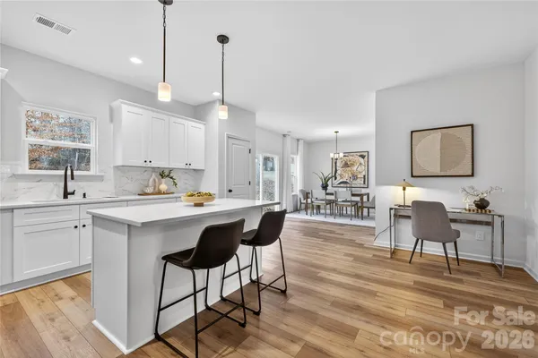 a living room with stainless steel appliances kitchen island granite countertop furniture and a wooden floor