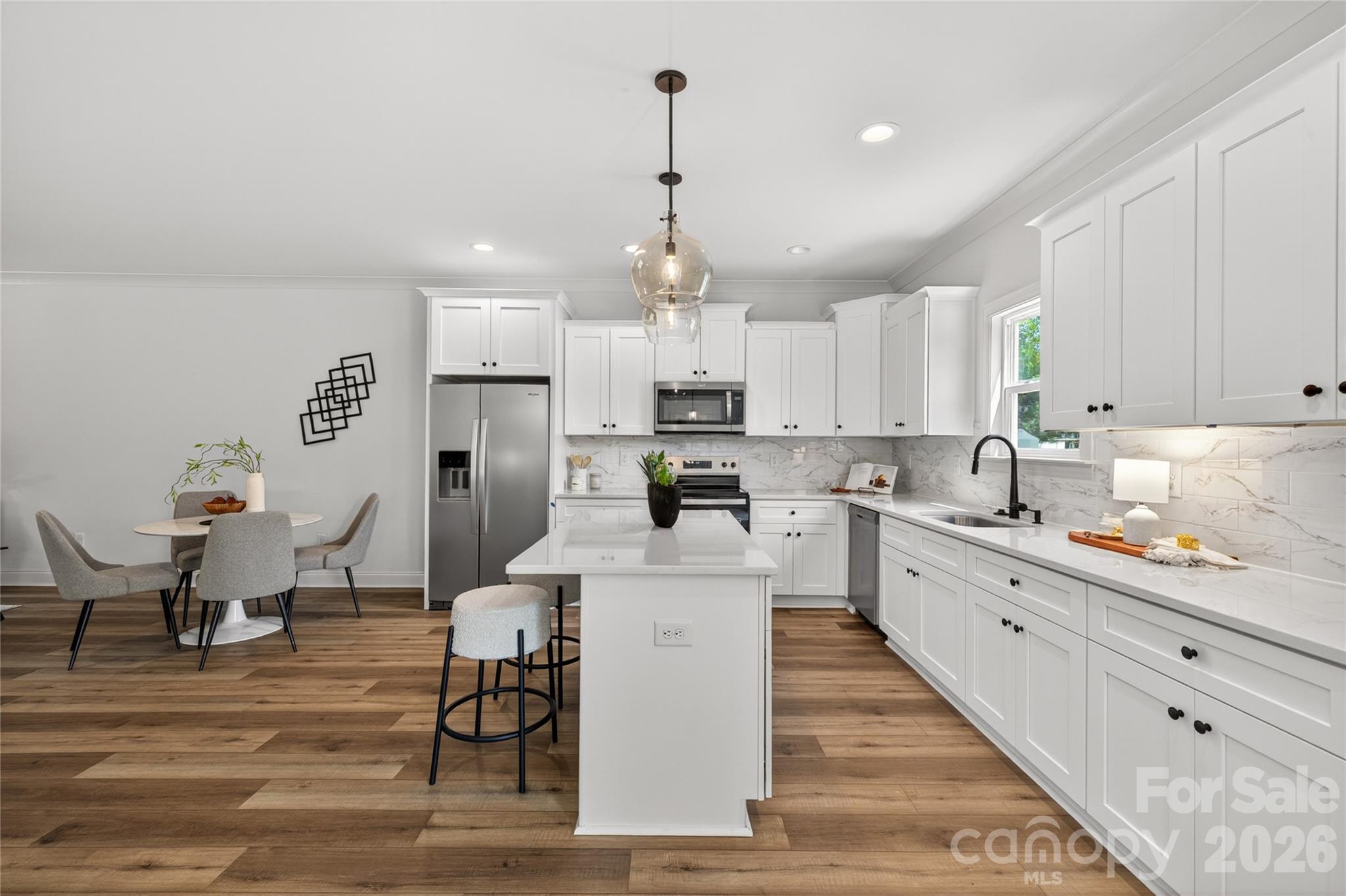 2965 Polk And White Road Charlotte, NC 28269 - Photo 8 of 38 a large white kitchen with lots of counter space wooden floor and appliances