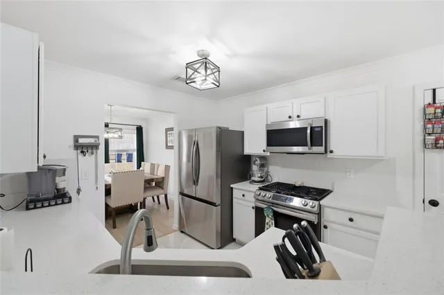 a kitchen with stainless steel appliances kitchen island granite countertop a refrigerator and a stove top oven