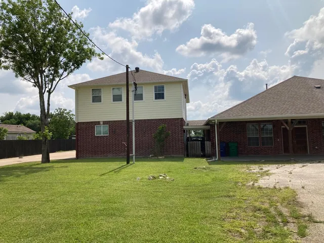 a view of a house with a yard and tree