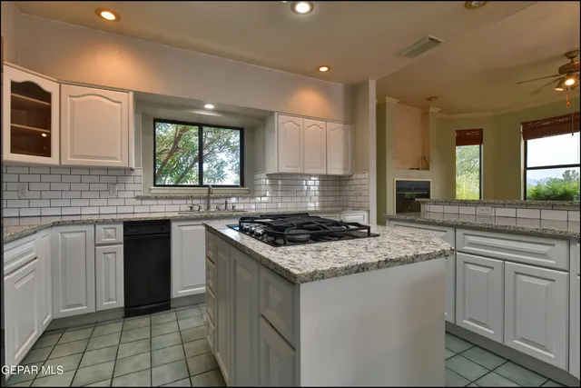 an empty room with windows and fireplace
