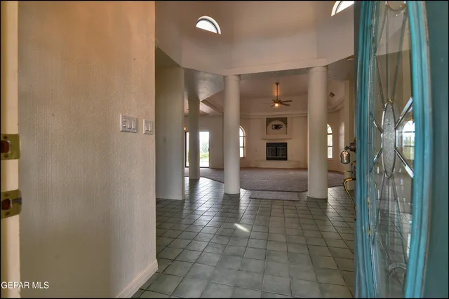 an empty room with a fireplace and windows