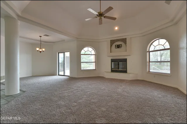 a view of a room with a chandelier fan and windows