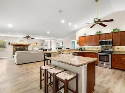 a living room with stainless steel appliances kitchen island granite countertop furniture and a view of kitchen