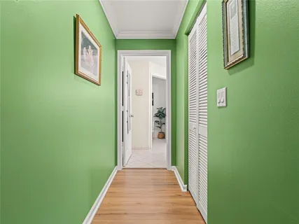 a view of a hallway with wooden floor and a bathroom