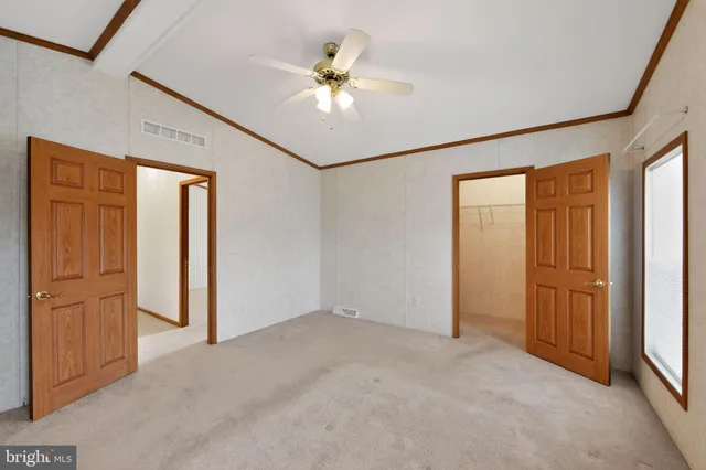 an empty room with windows and fan