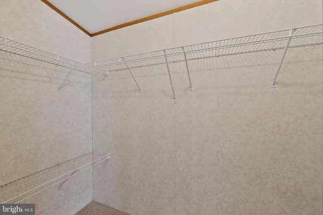 an empty room with chandelier fan and windows