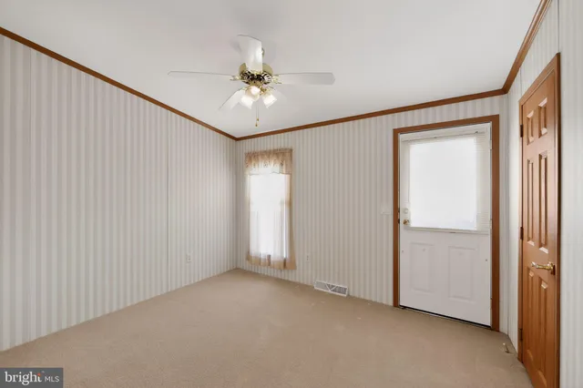 a view of an empty room with a ceiling fan