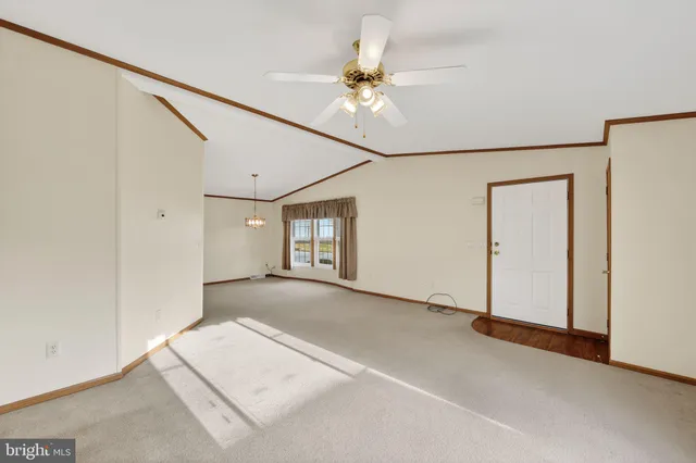 an empty room with a ceiling fan and windows