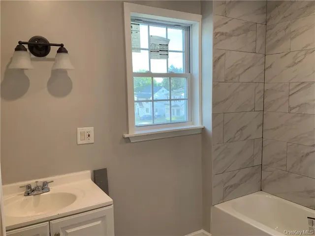 a view of hallway with a large window and wooden floor