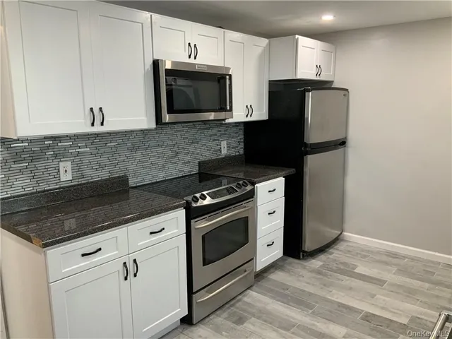 a kitchen with appliances a sink and cabinets