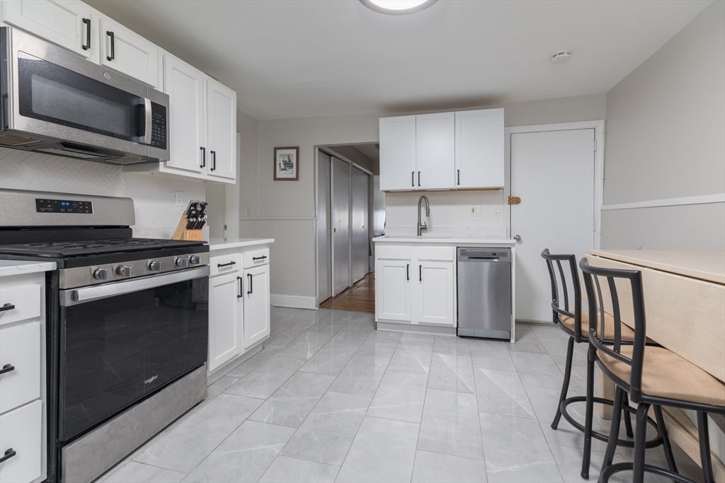 69 I Street, Unit 3 Boston, MA 02127 - Photo 6 of 14 a kitchen with stainless steel appliances granite countertop a stove a sink dishwasher a refrigerator and a microwave